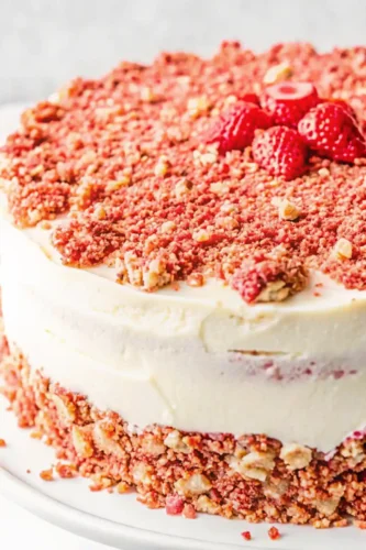 Close-up of strawberry crunch cake with creamy frosting and crunchy topping.