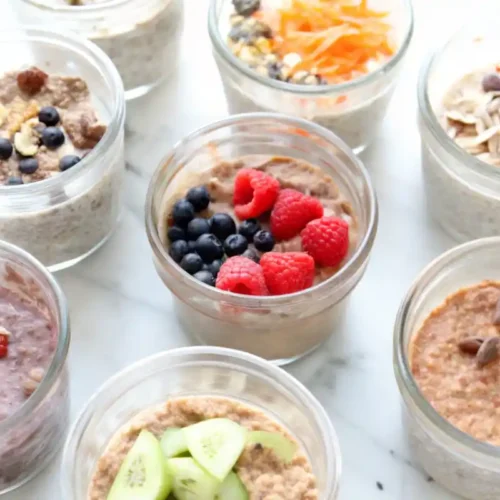 Multiple jars of overnight oats with various toppings like berries, cucumbers, and seeds.