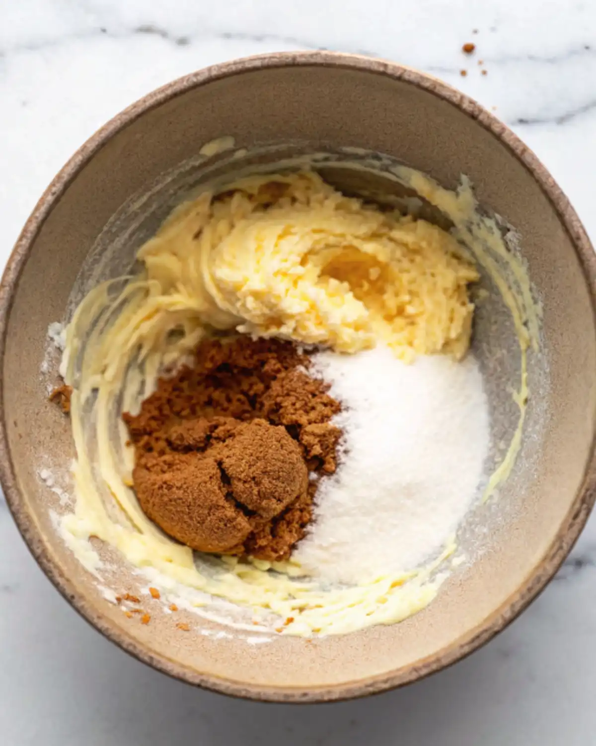 Brown and white sugar with butter in mixing bowl